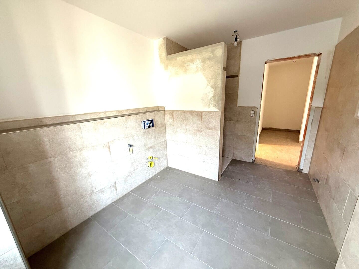 Küche mit Fliesenboden und Anschlussmöglichkeiten – offener Kochbereich im Neubau