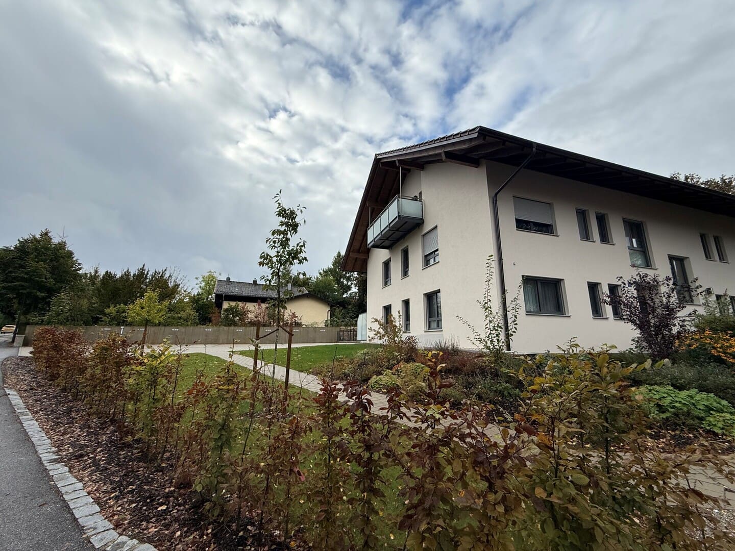 Außenansicht des Mehrfamilienhauses mit gepflegter Gartenanlage – Neubauwohnung in zentraler Lage von Obing