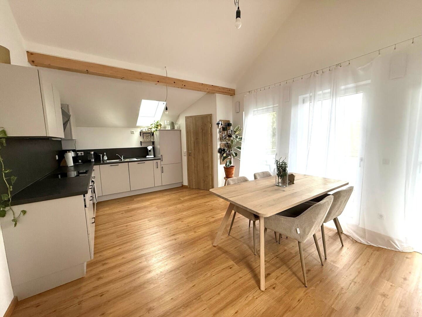 Heller Wohnbereich mit offener Küche und Vinylboden – moderne Dachgeschosswohnung mit Aufzug in Obing