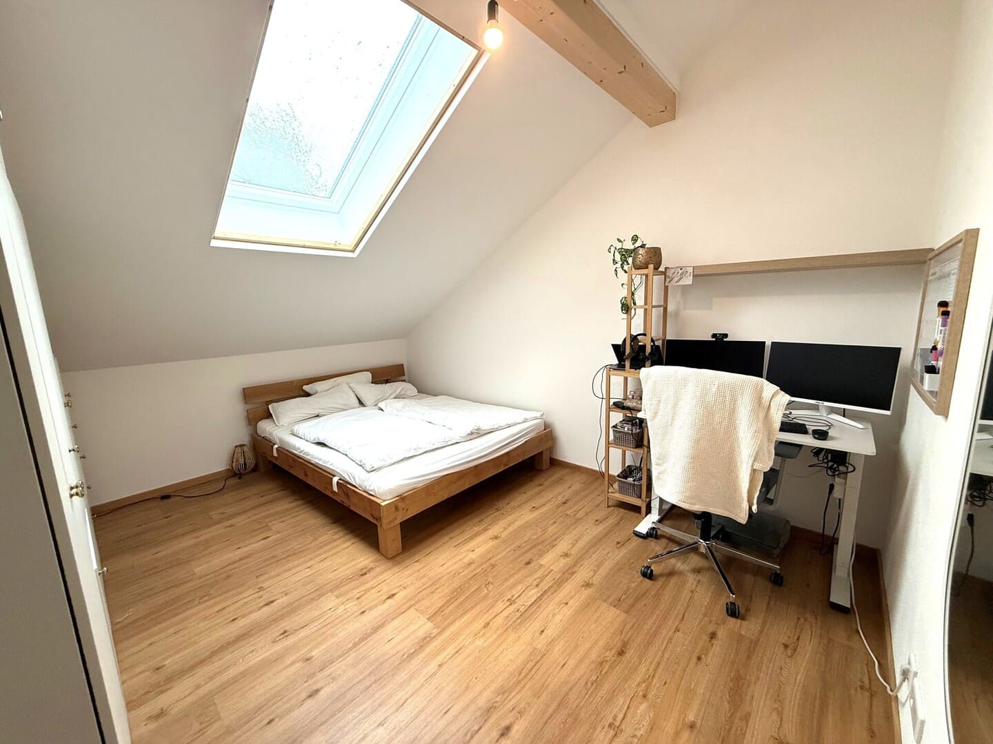 Schlafzimmer mit Dachschräge, großem Fenster und hellem Boden – gemütlicher Schlafbereich in Obing