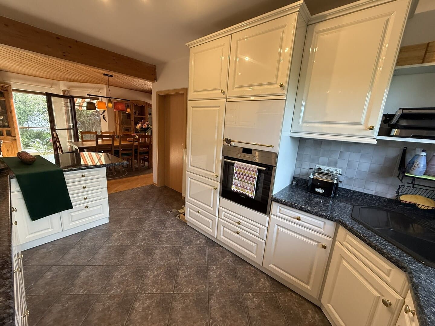 Hochwertige Einbauküche im Einfamilienhaus Edling mit weißen Fronten und Zugang zum Essbereich