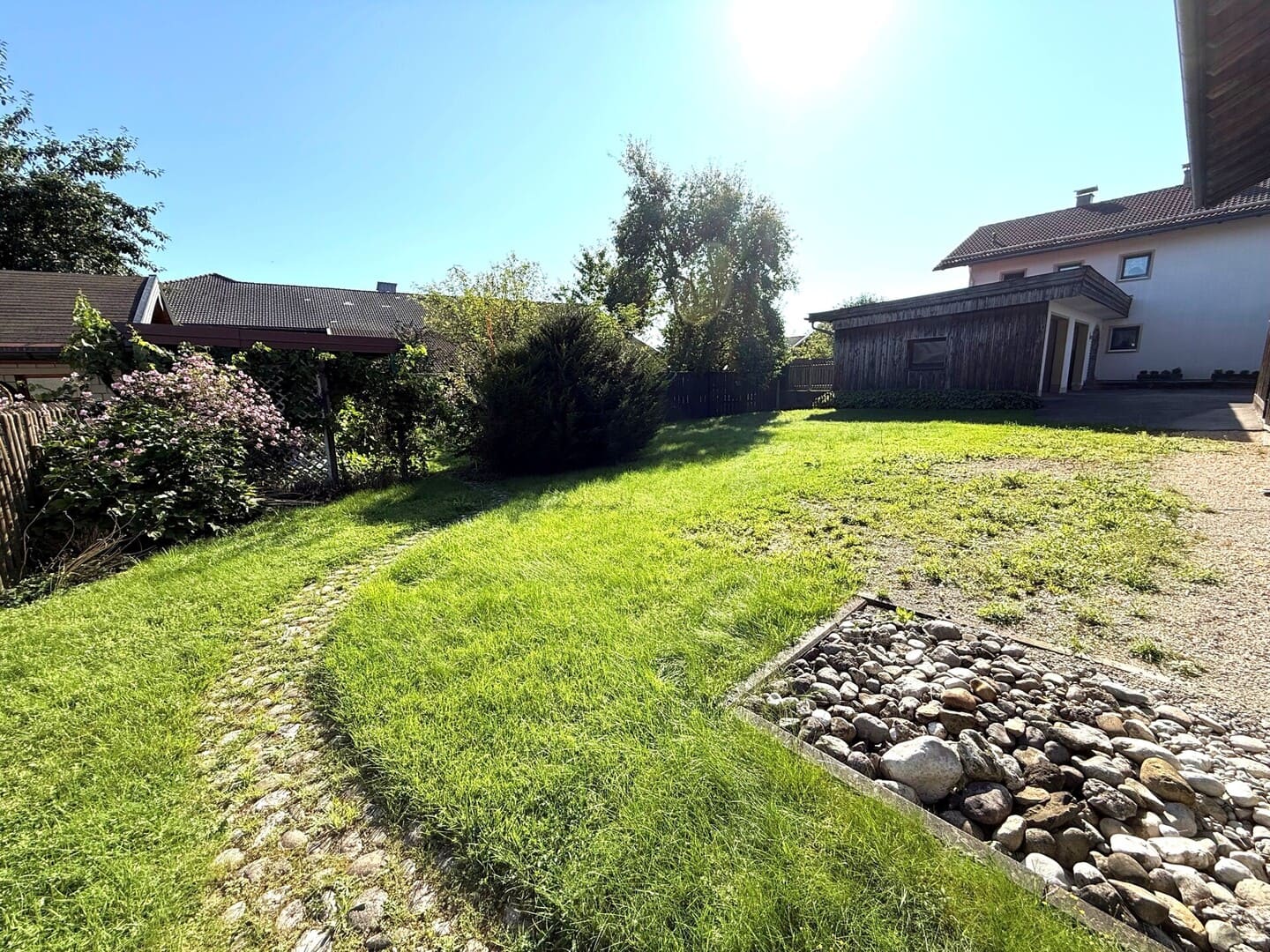 Grünes Grundstück in Seeon mit leichter Hanglage und Steinmauer – zentrumsnahes Baugrundstück im Chiemgau.