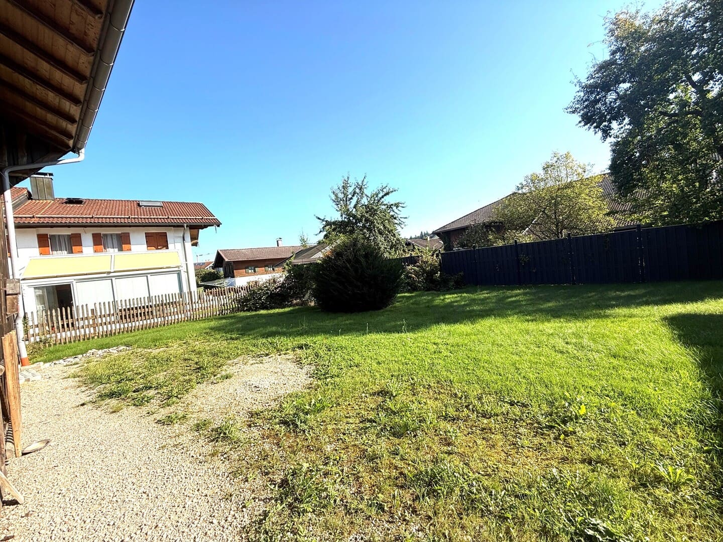 Baulücke in Seeon mit Zufahrt und Blick auf Nachbarhäuser – attraktives Grundstück nahe dem Seeoner See und Ortszentrum.