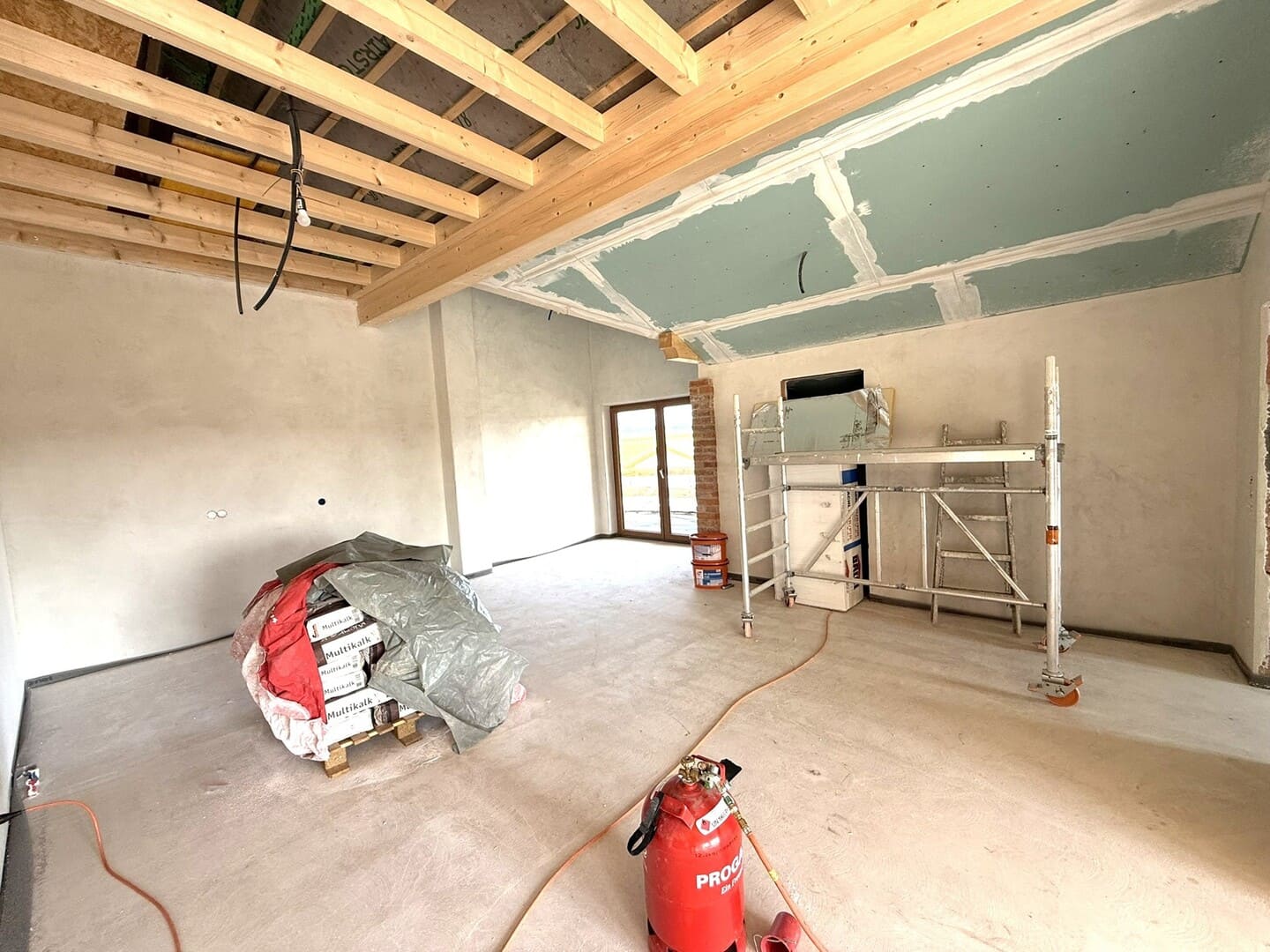 Küche oder Wohnbereich im Rohbau mit vorbereiteten Anschlüssen – moderne 3-Zimmer-Dachgeschosswohnung.