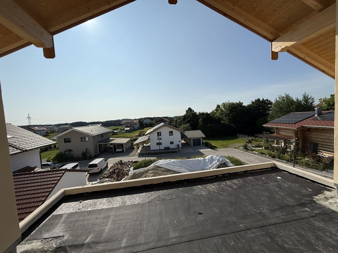 Dachterrasse mit Blick auf die Berge und umliegende Neubauten – sonnige Südwestlage der Penthouse-Wohnung.