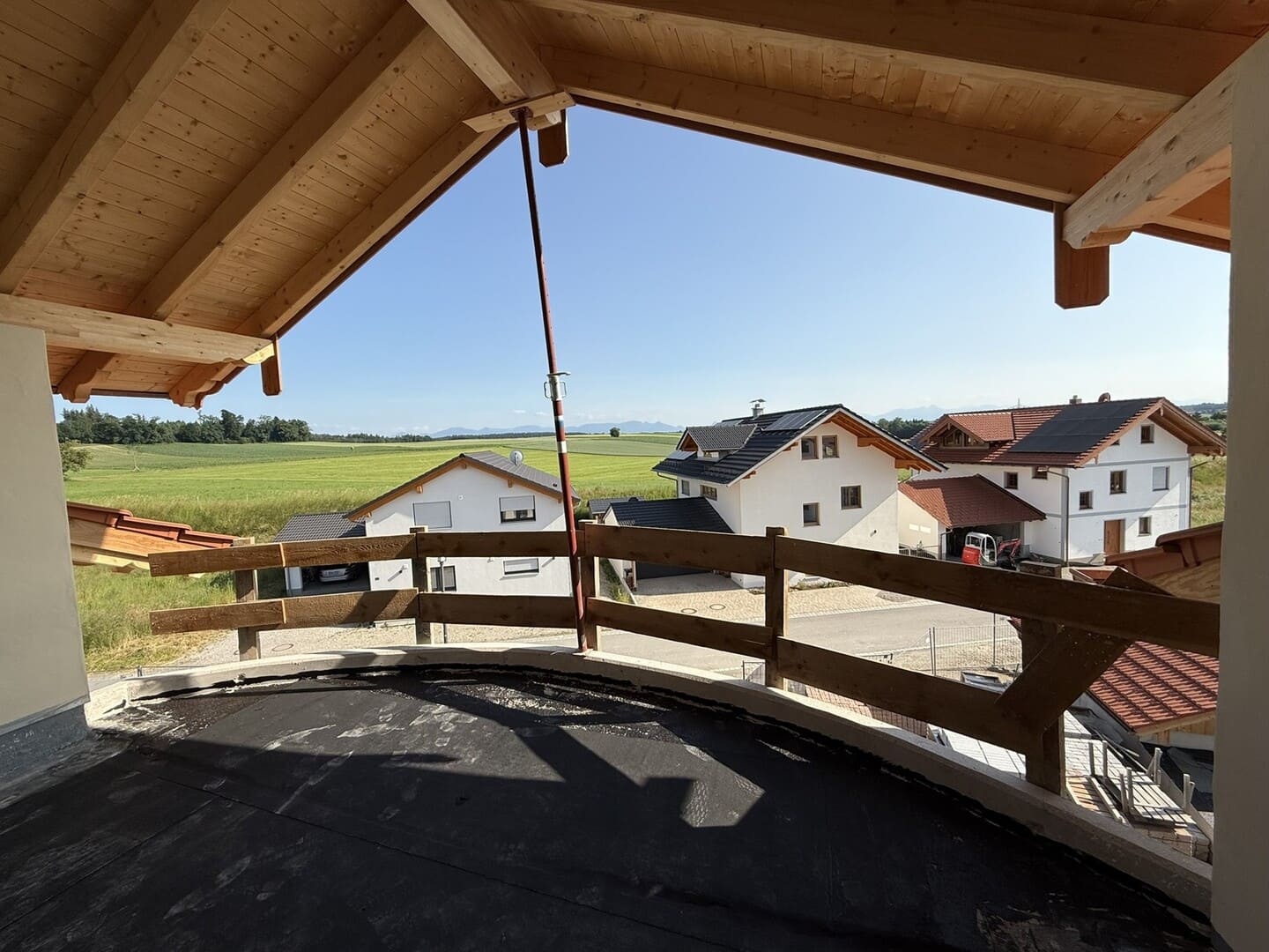 Überdachte Westterrasse mit freiem Blick über Schonstett – großzügige Dachterrasse mit Holzgeländer.