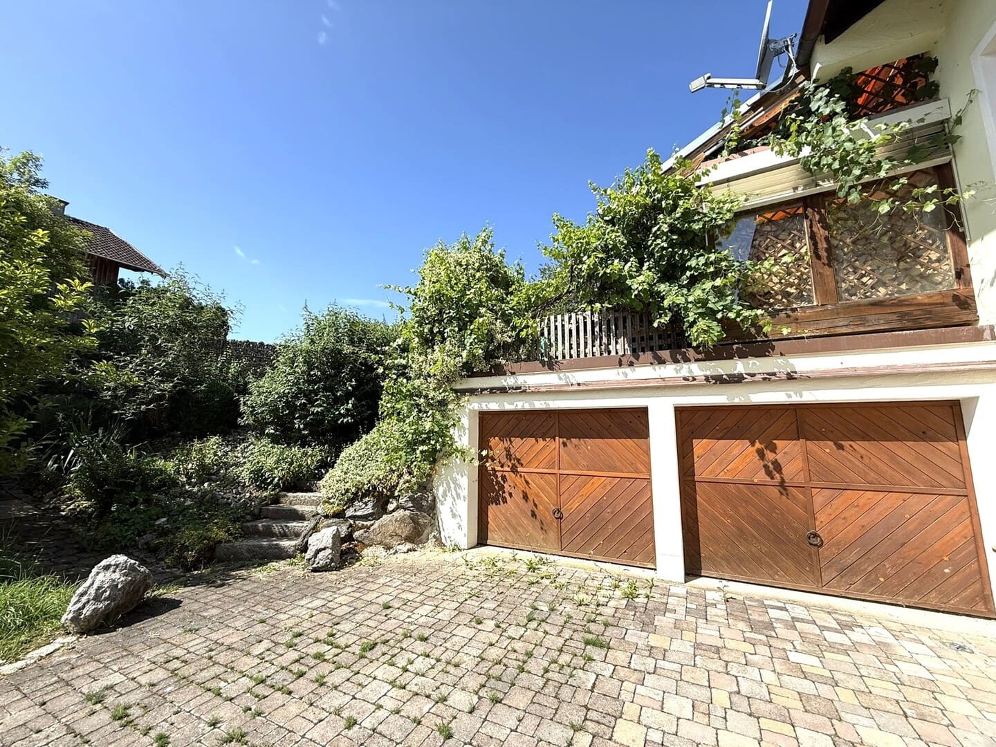 Doppelgarage mit gepflasterter Zufahrt und Platz für Fahrzeuge oder Gartengeräte.