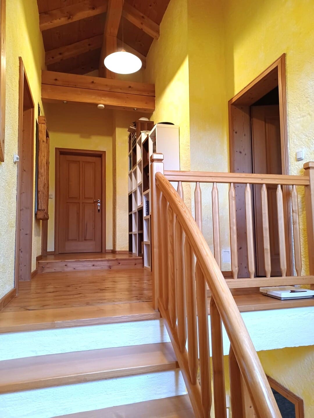 Heller Eingangsbereich mit Holztreppe und Fliesenboden – gepflegter erster Eindruck beim Betreten des Hauses.