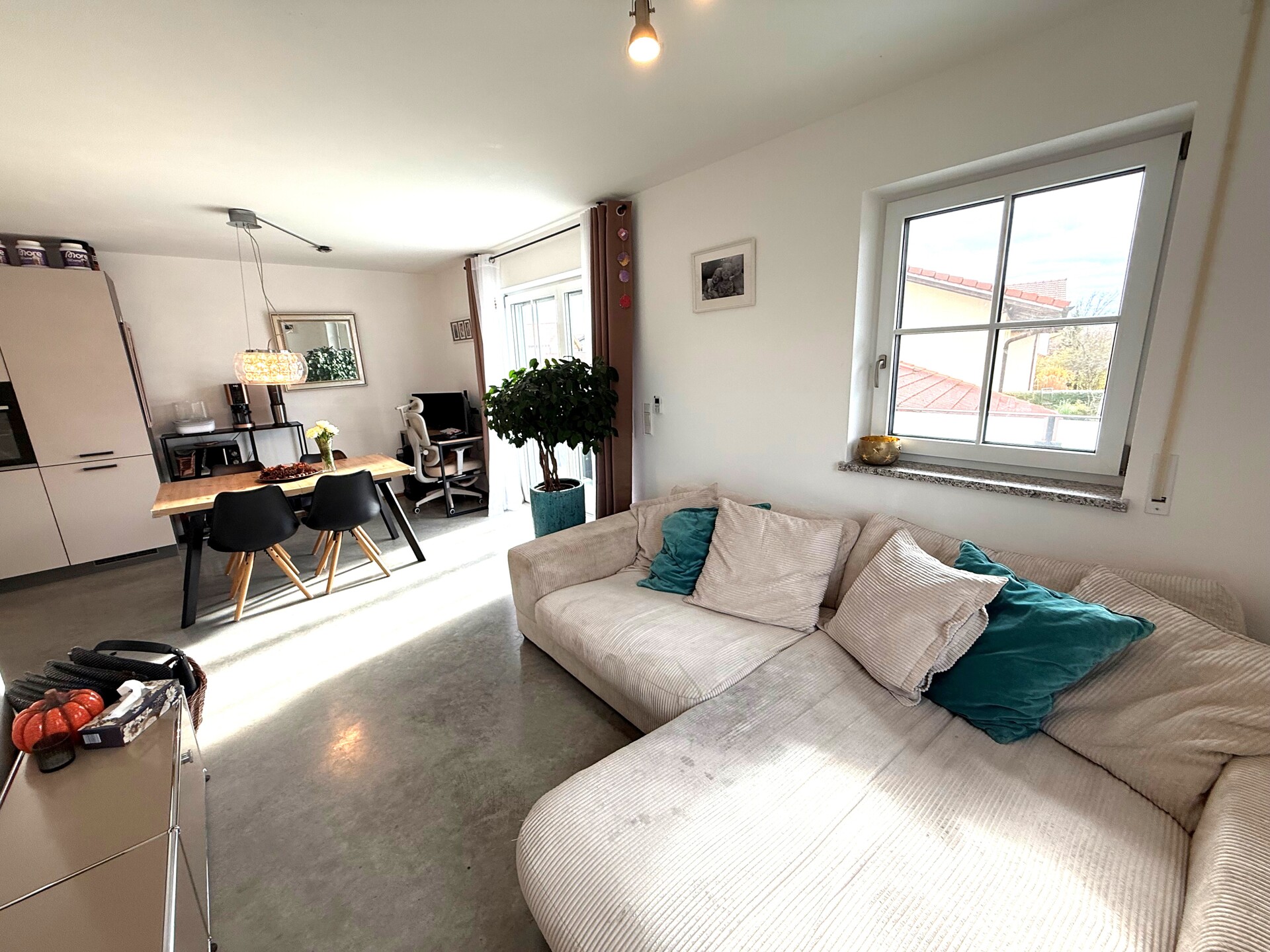 Helles Wohnzimmer mit Sofa, Teppich und großem Fenster.