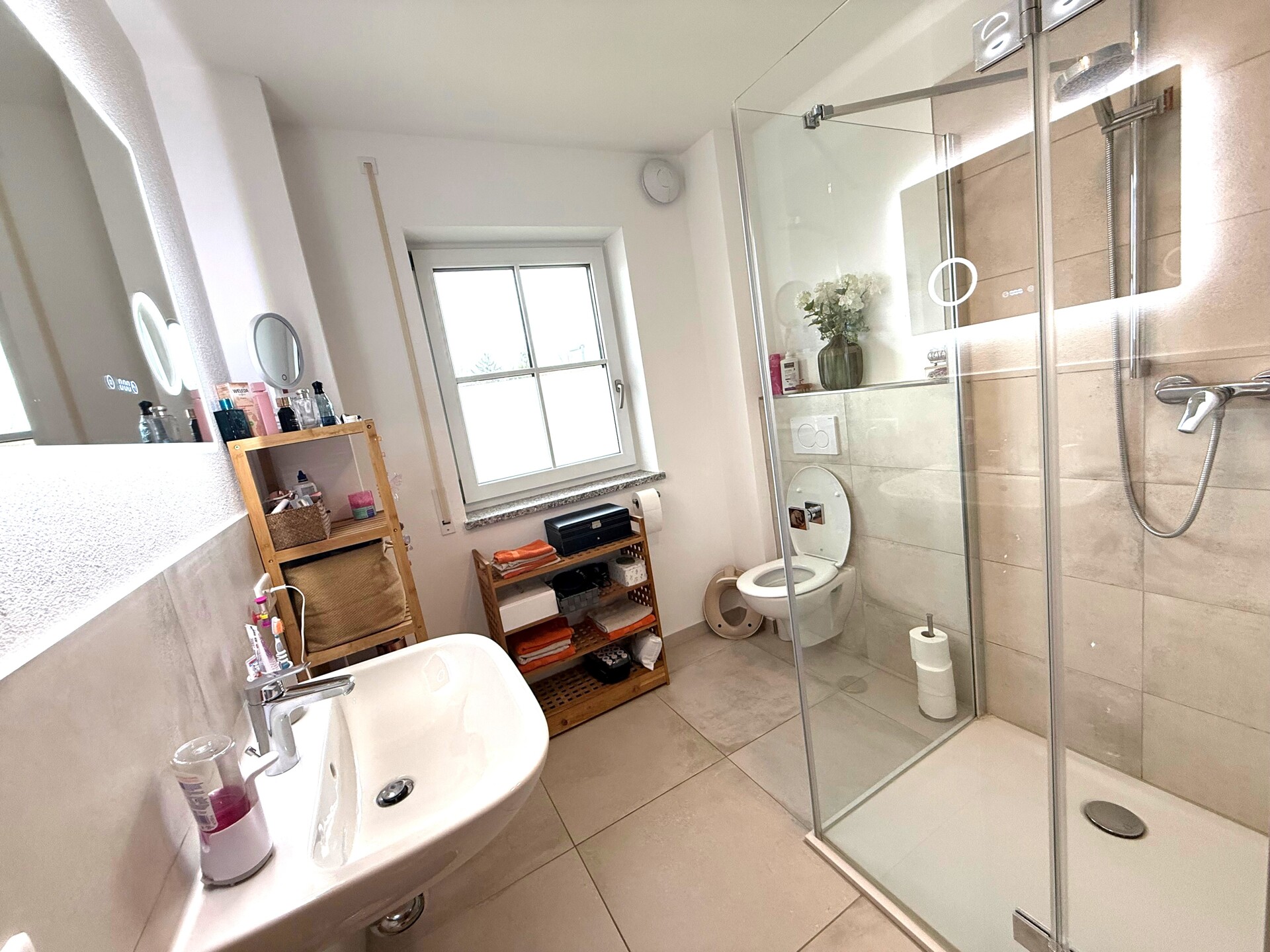 Modernes Bad mit Glasdusche und hellen Fliesen.