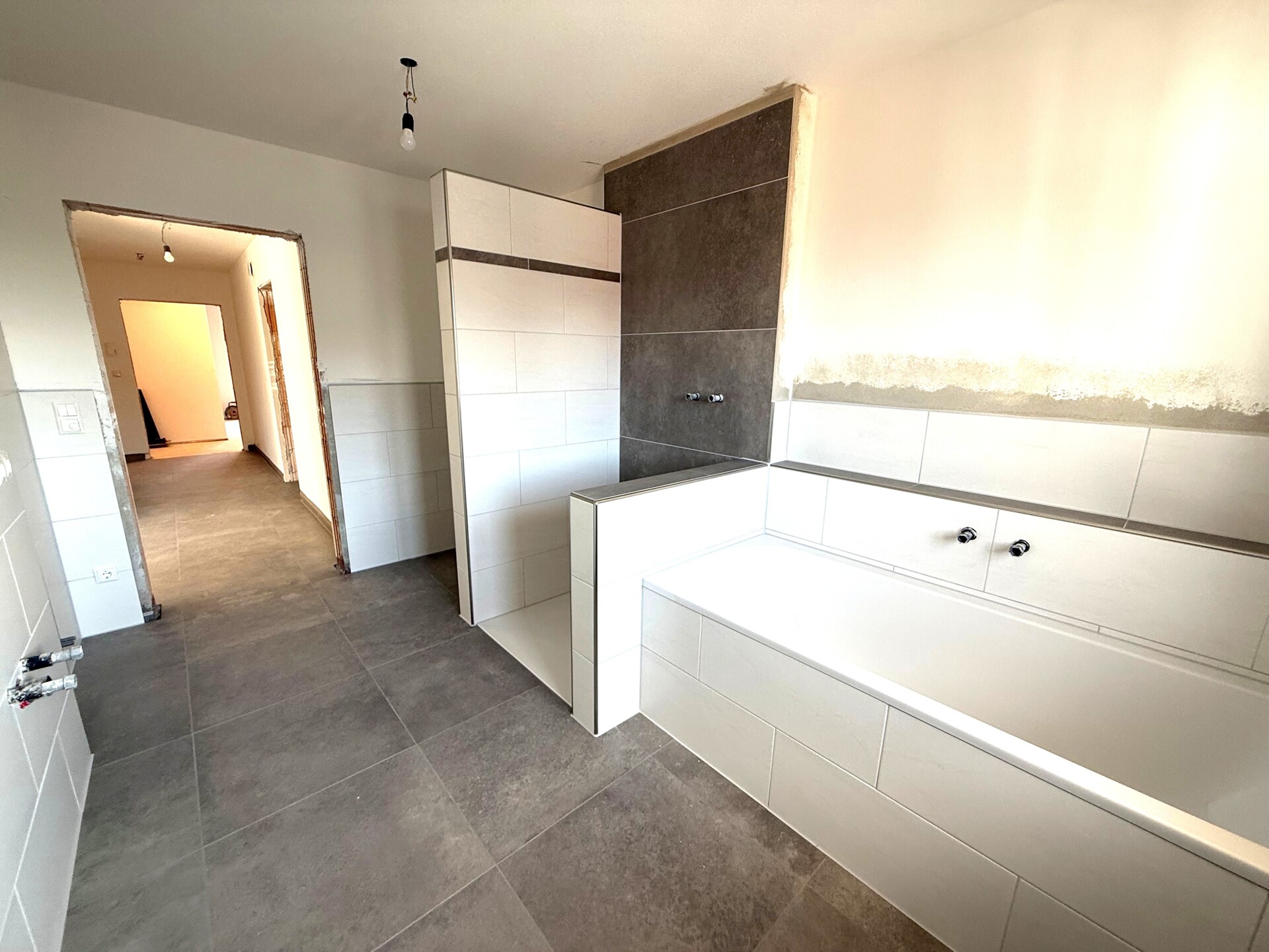 Moderne Küche mit weißen Schränken in einem noch leeren Raum.