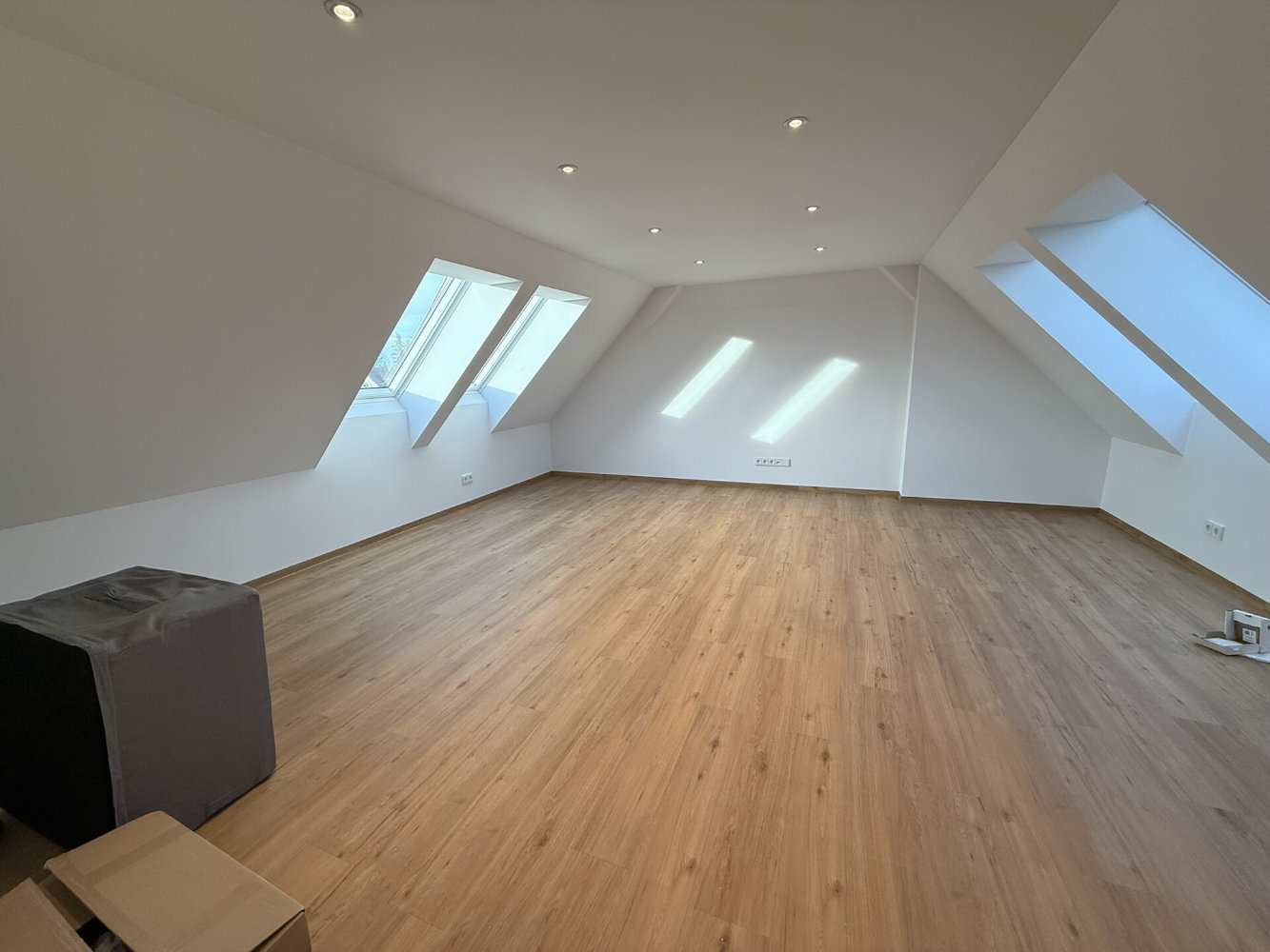 Moderner Essbereich mit Holztisch und blauen Stühlen, offener Küche mit Tresen und großen Fenstern zum Garten.