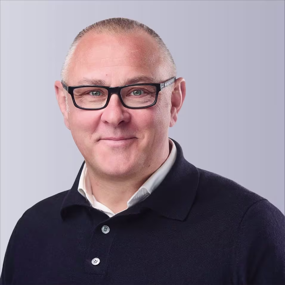 Two professionals shaking hands outdoors, symbolizing partnership and collaboration.