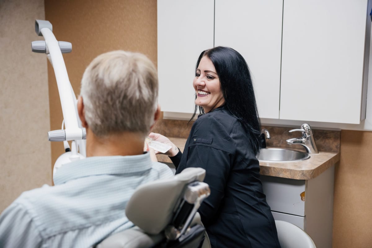 Female dentist examining a patient's teeth during a dental procedure in treatment chair