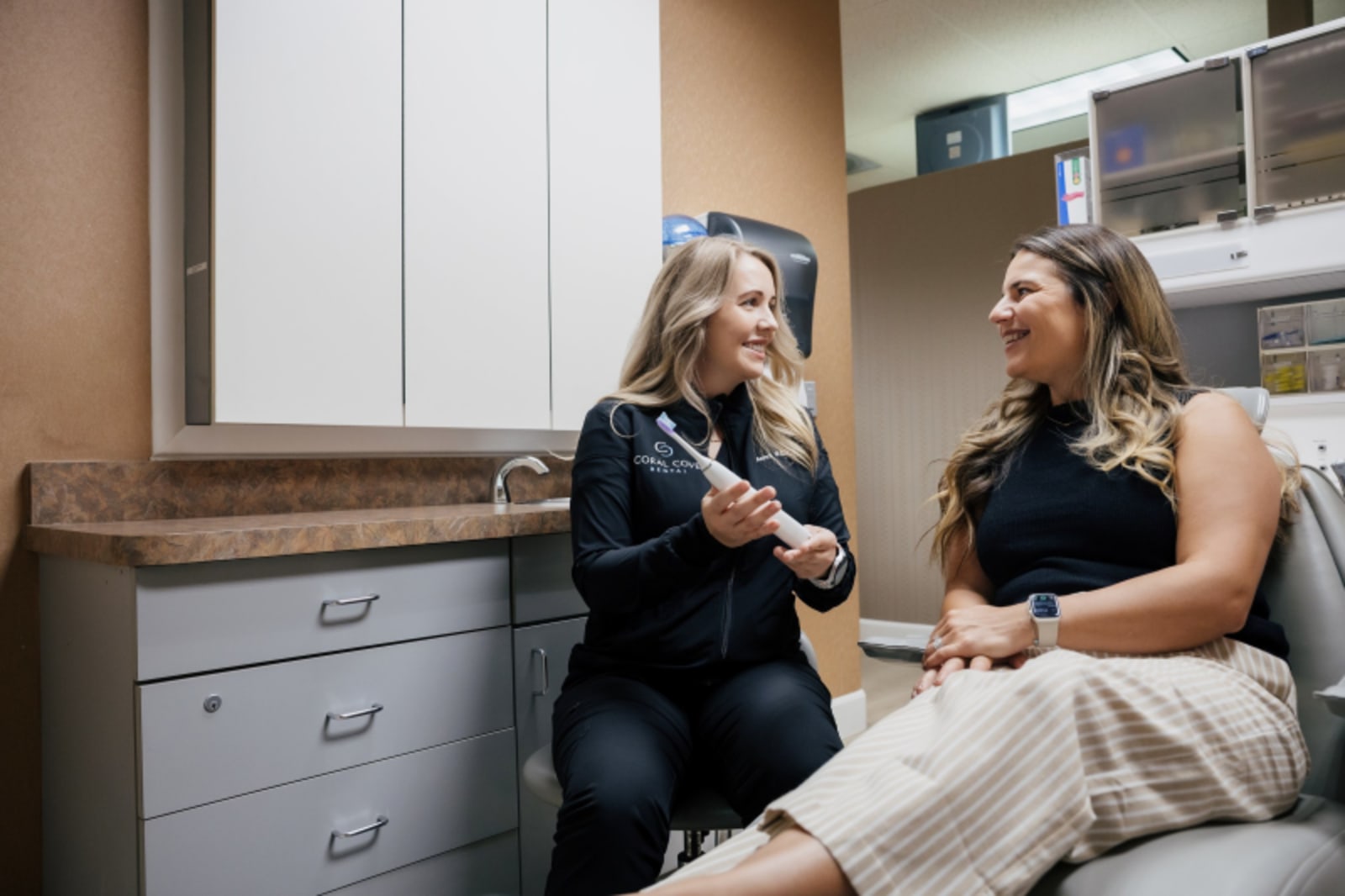 Dentist discussing treatment plan with female patient in clinical setting