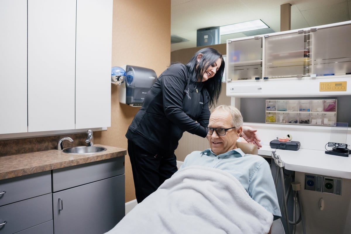 Dental professional examining a patient's teeth during a clinical procedure at Coral Cove Dental