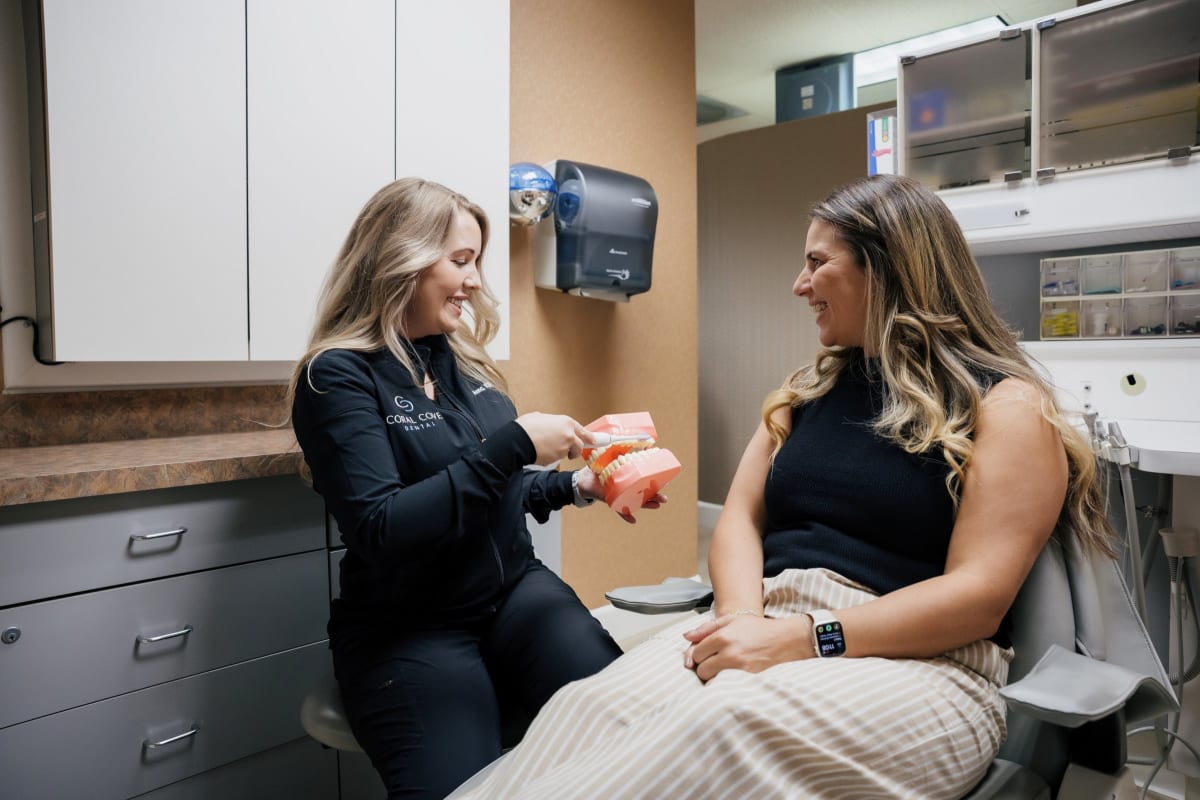 Female dentist discussing treatment plan with female patient in clinical exam room