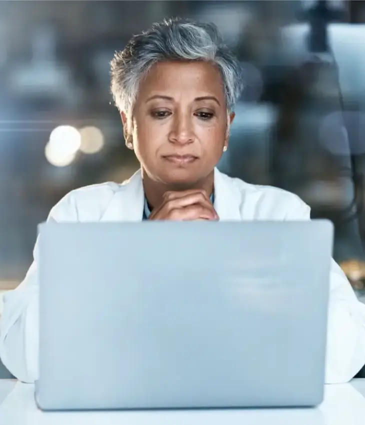 Professional reviewing information on a laptop representing Jopari ProPay’s tailored payment solutions for Property and Casualty claims