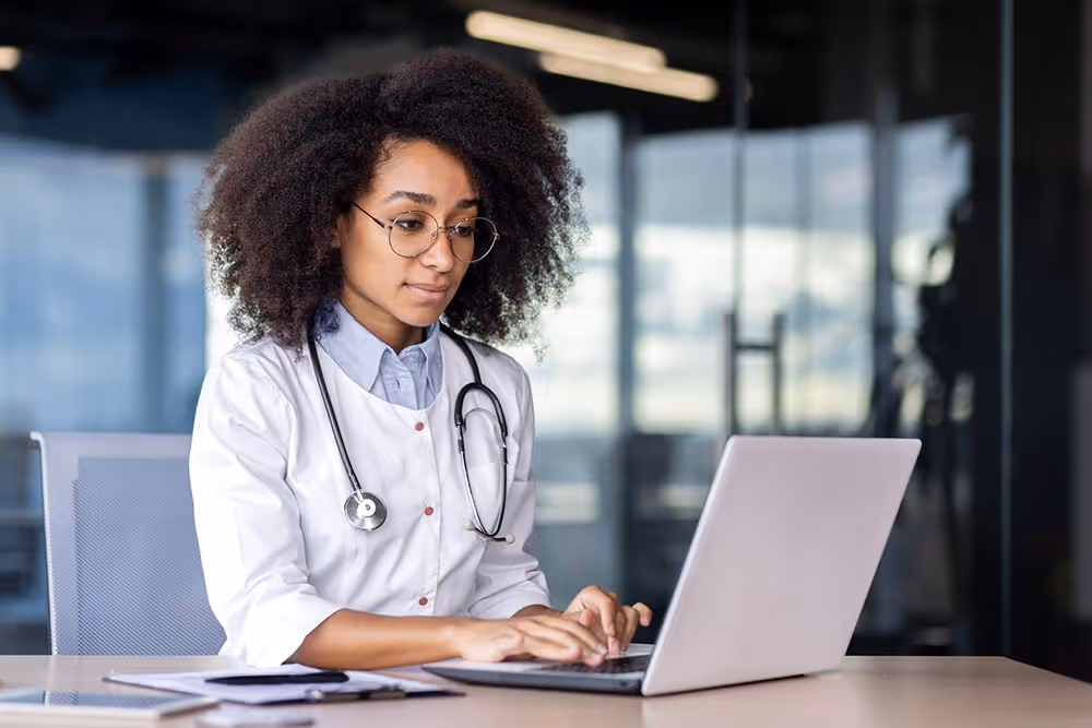 Clinician using a laptop with financial and healthcare icons representing Jopari ProPay’s seamless electronic claims payment processing
