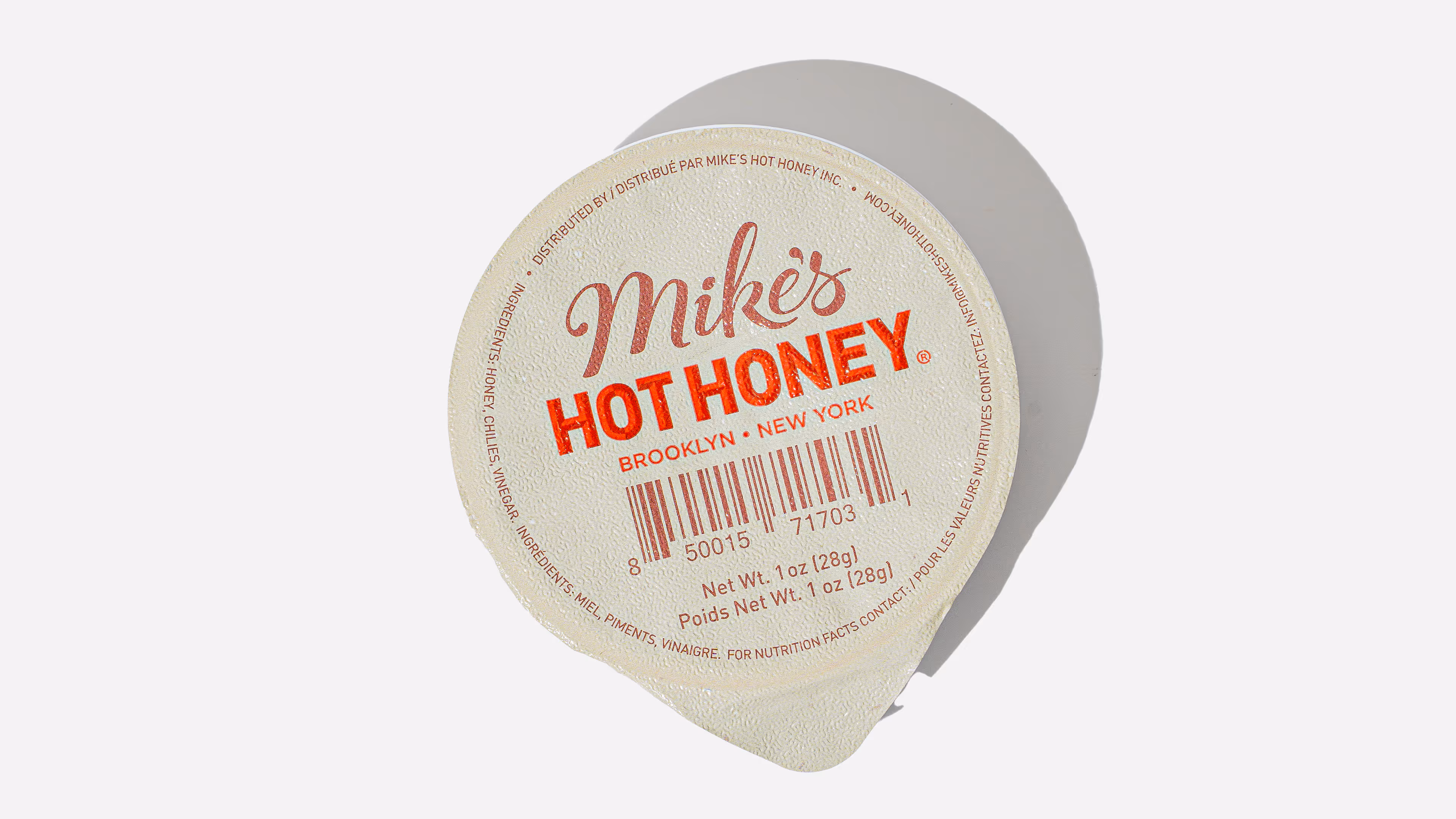 Single-serving packet of Mike's Hot Honey with label showing Brooklyn, New York, barcode, and net weight of 1 oz (28g).