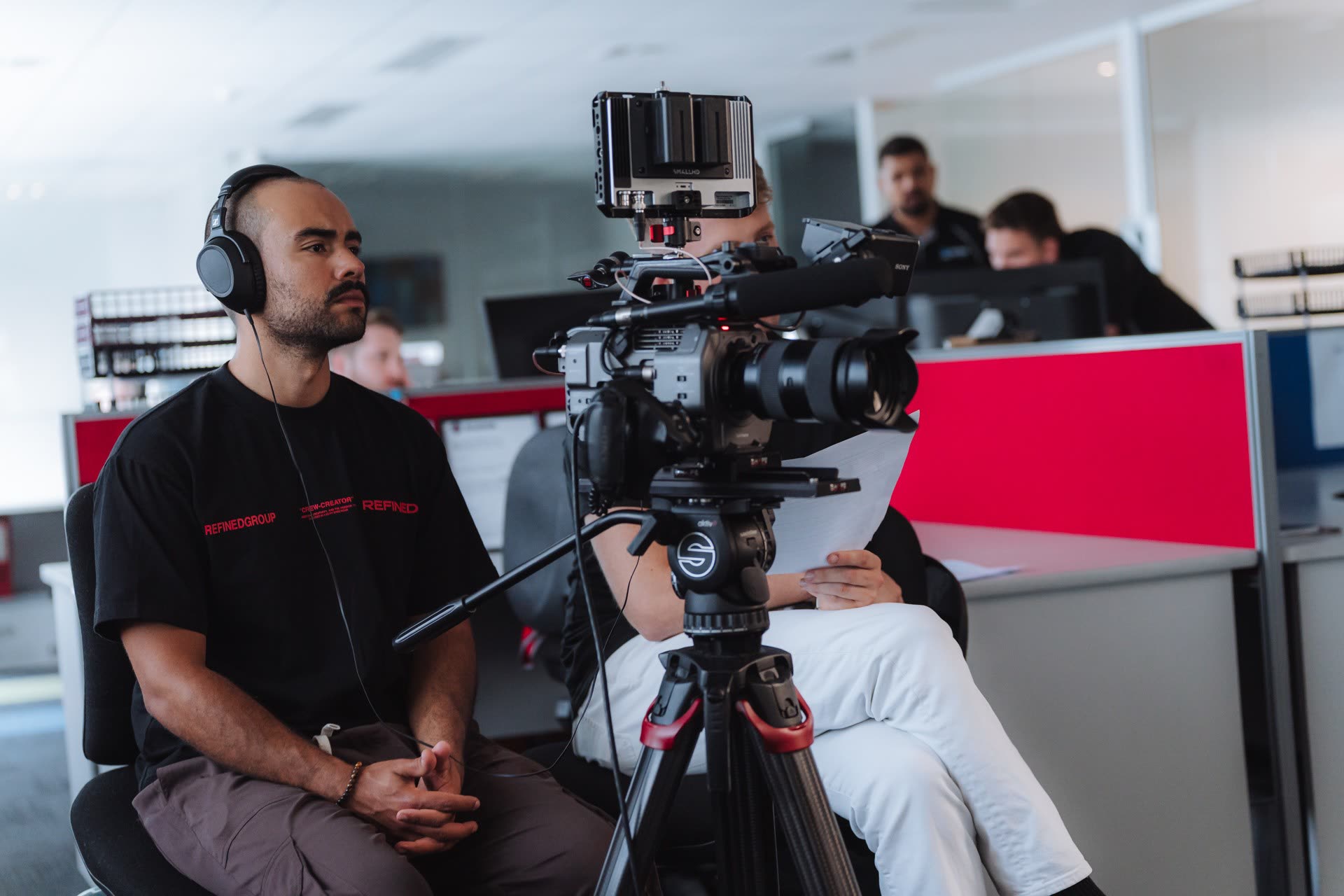 Refined crew filming an interview in an office