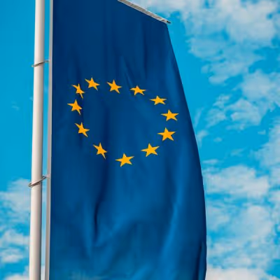 Drapeau de l’Union européenne flottant sous un ciel bleu, illustrant la candidature de Clermont-Ferrand au titre de Capitale européenne de la Culture 2028.