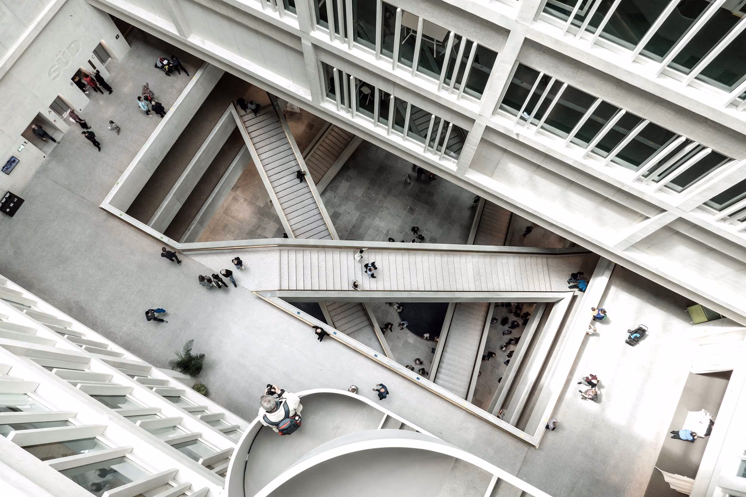 Architecture intérieure d’un bâtiment moderne, avec escaliers et perspectives géométriques.