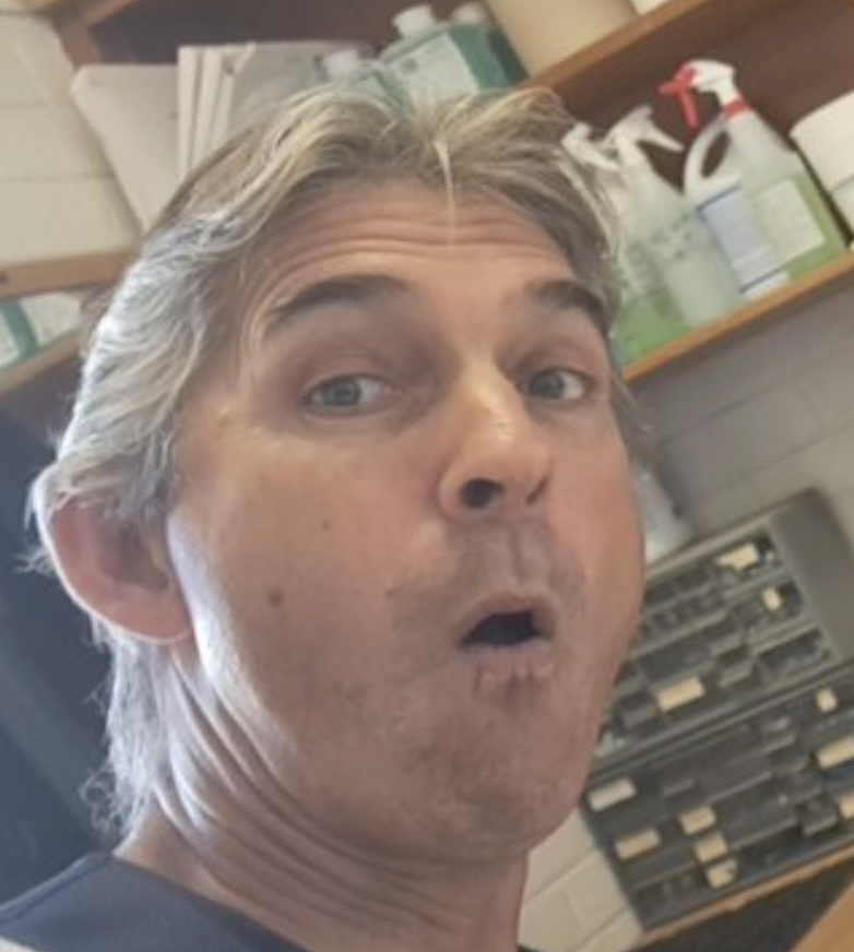 Middle-aged man with gray hair making a surprised or shocked facial expression.