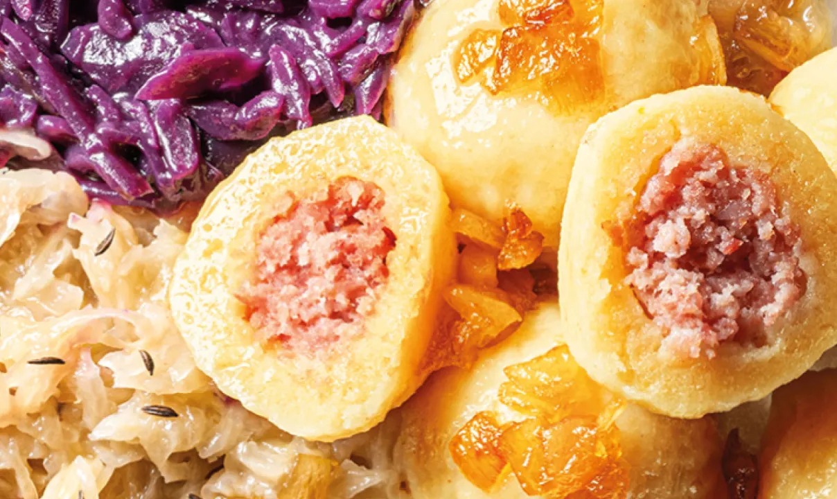 Tvarohové knedlíky plněné mletým masem podávané s dušeným červeným a bílým zelím.