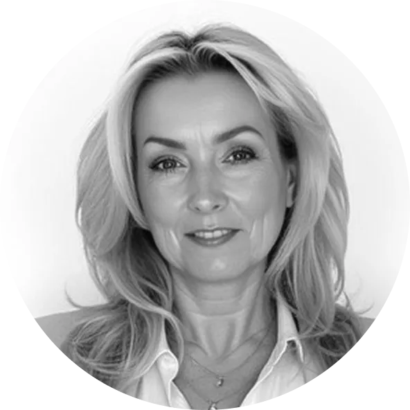 Černobílý portrét středně staré ženy s dlouhými světlými vlasy a jemným úsměvem.