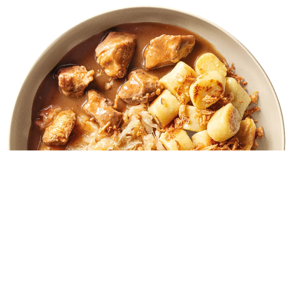 Talíř s kousky vepřového masa v hnědé omáčce, smaženými bramborovými knedlíky a kysaným zelím.