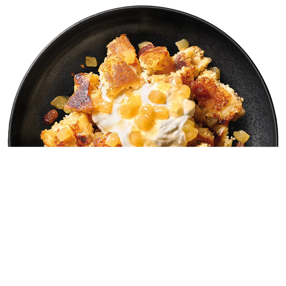 Talíř s trhaným těstem s kousky jablek, rozinek a zakysanou smetanou s jablečnou omáčkou.