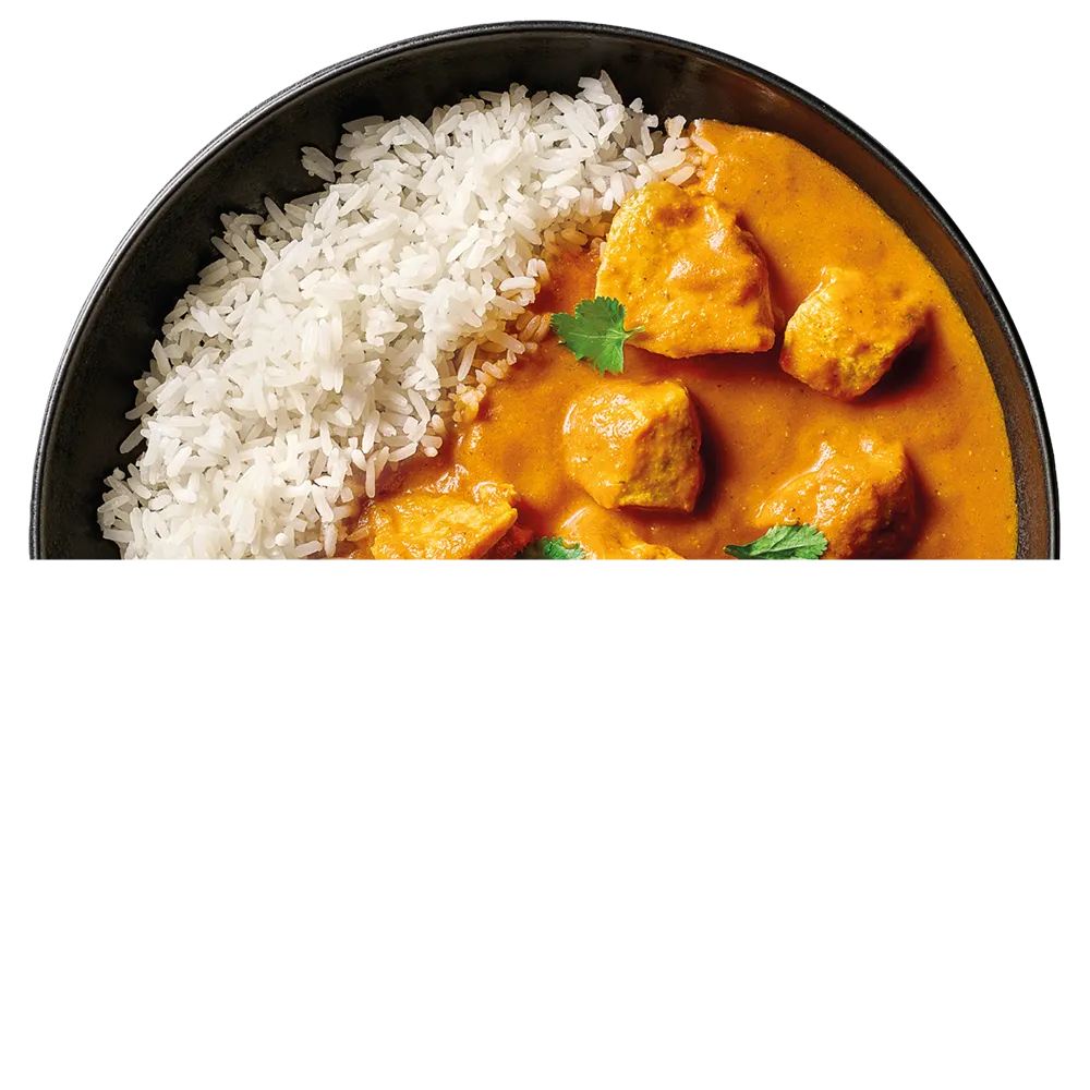 Černý talíř s bílou rýží a kousky kuřete v krémové oranžové omáčce garnované koriandrem.