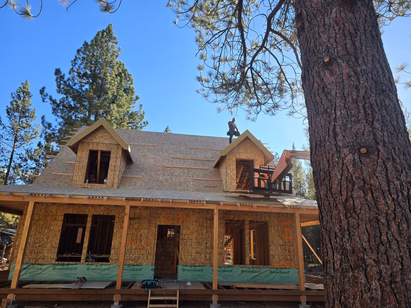 A house under construction in the woods.