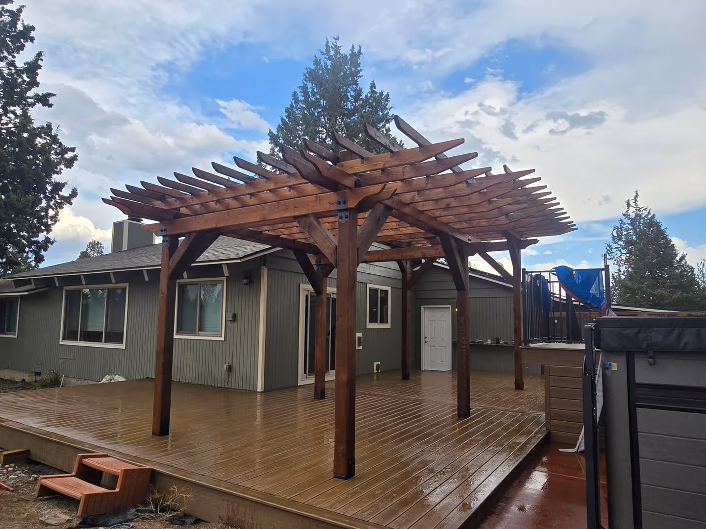 A wooden deck with a pergolan on top of it.