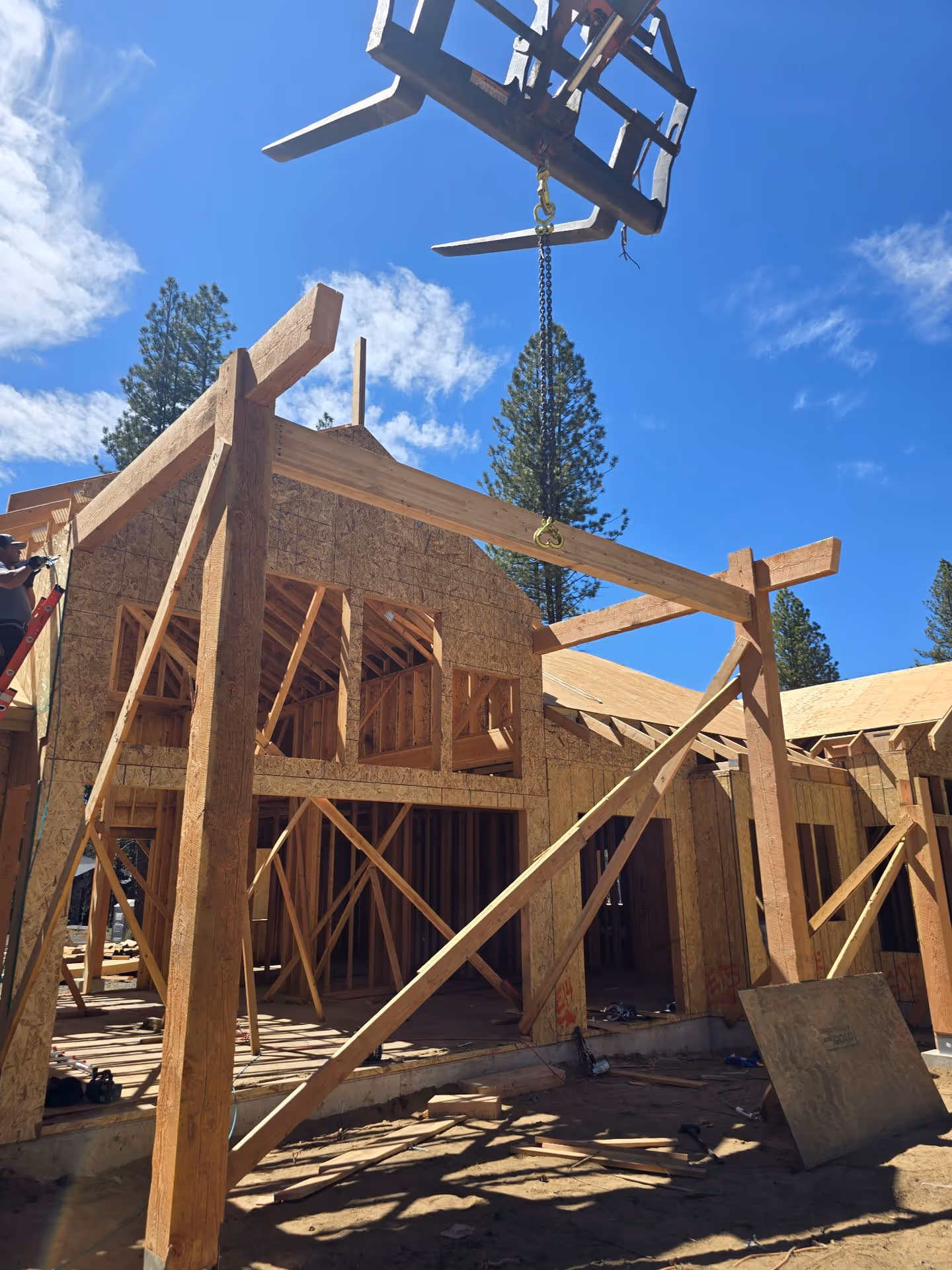 A house under construction with a crane in the air.