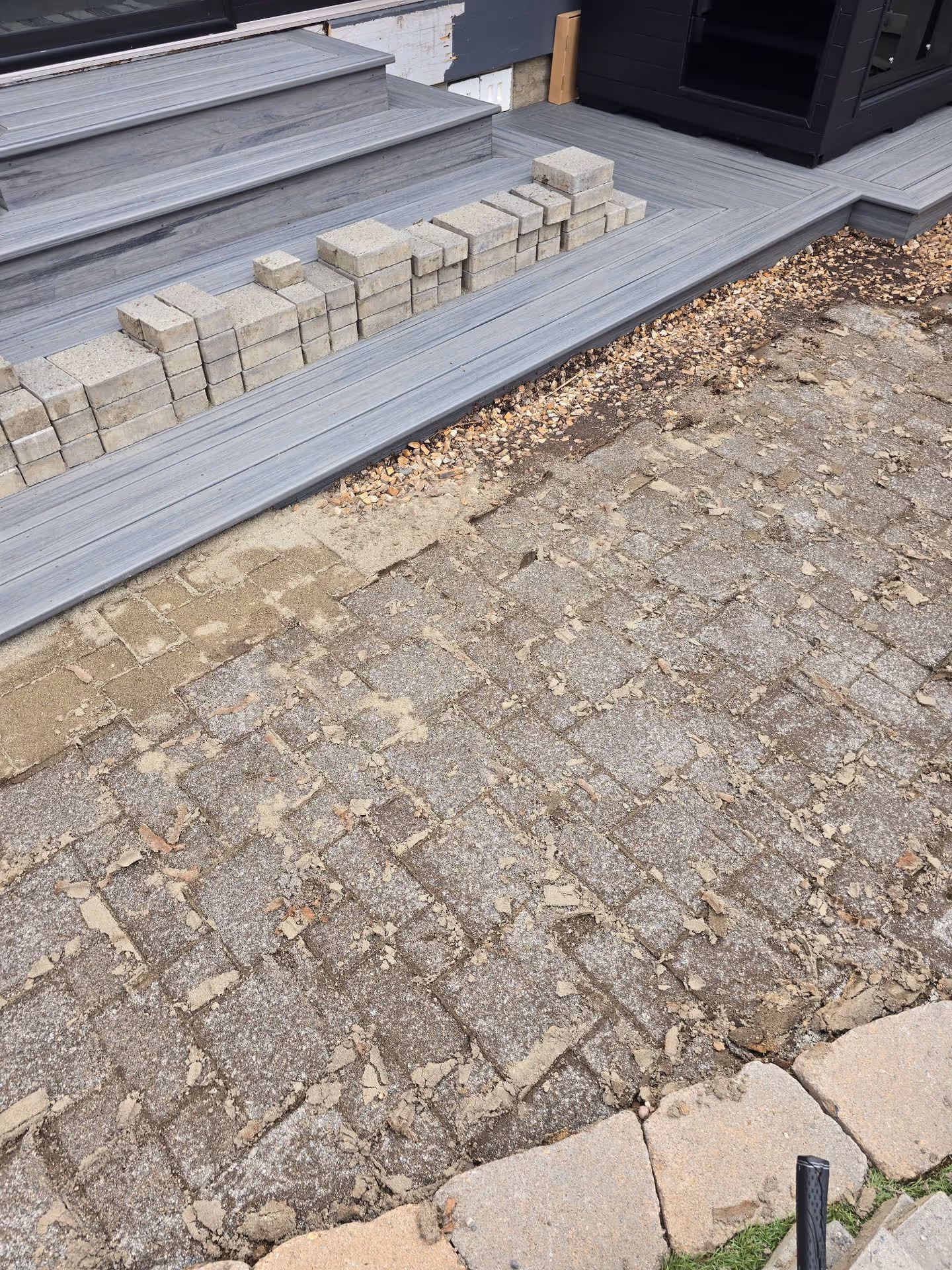 A cat is sitting on the steps of a house.