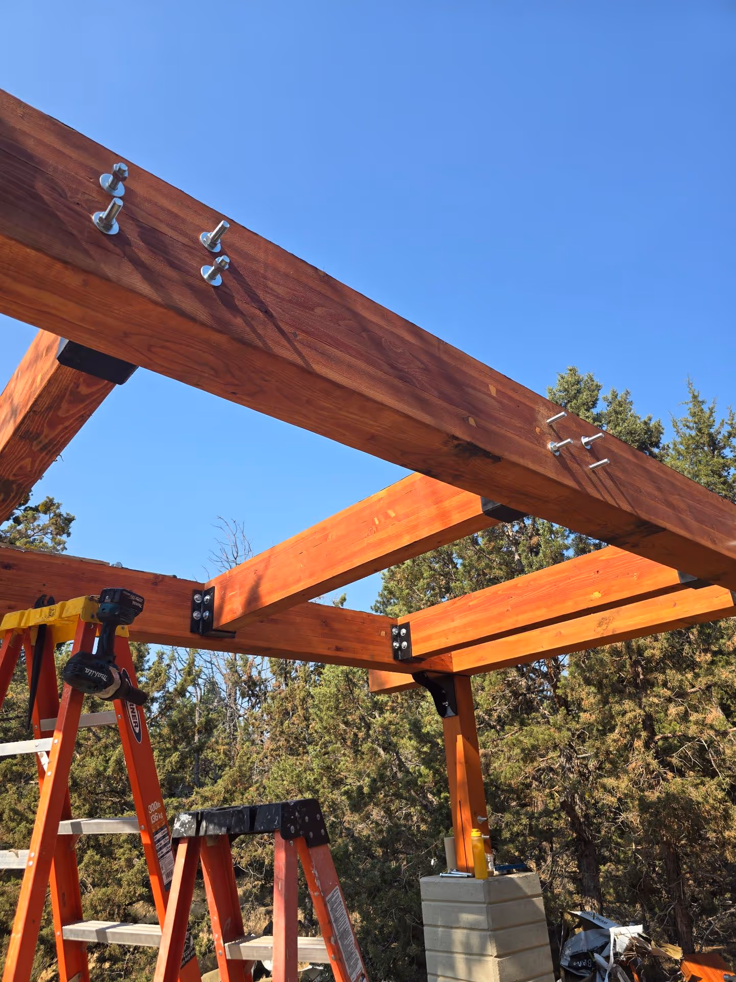 A wooden structure being built in a wooded area.