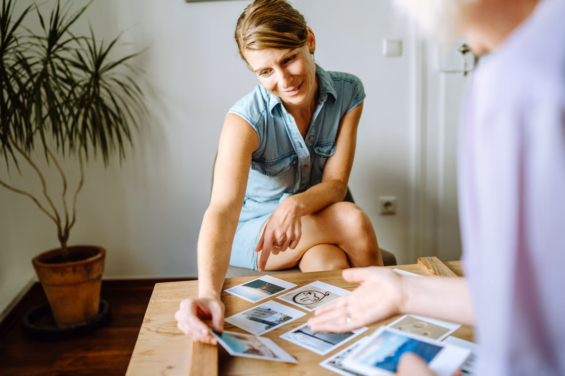Klientin nimmt sich Bildkarte vom Tisch.