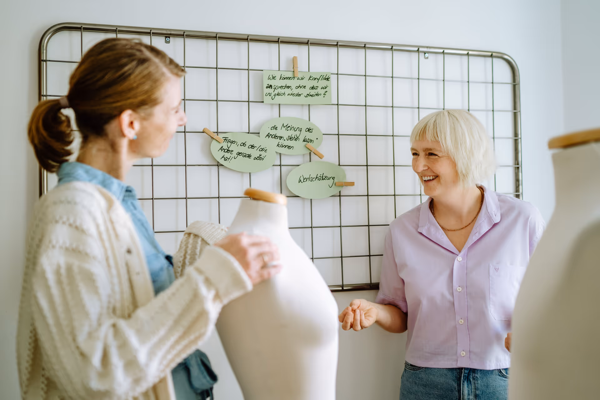 Wera und Klientin unterhalten sich bei Schneiderpuppen.