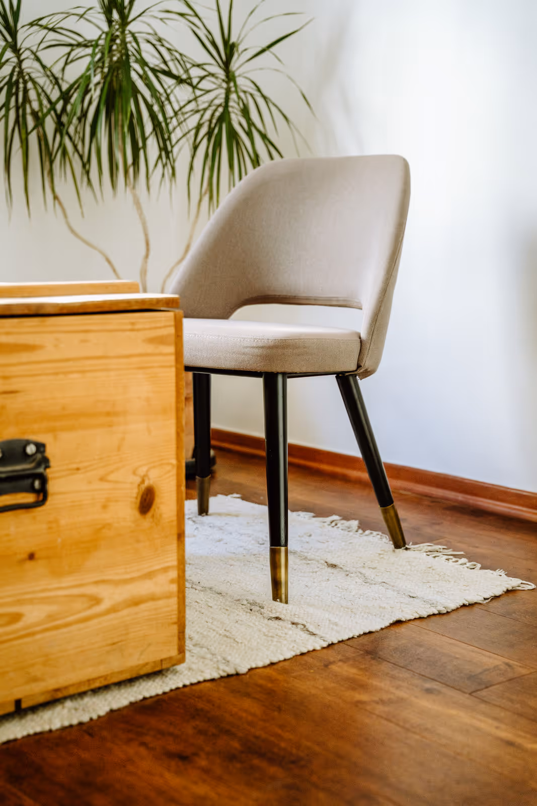 Stuhl neben einer Holztruhe auf Teppich