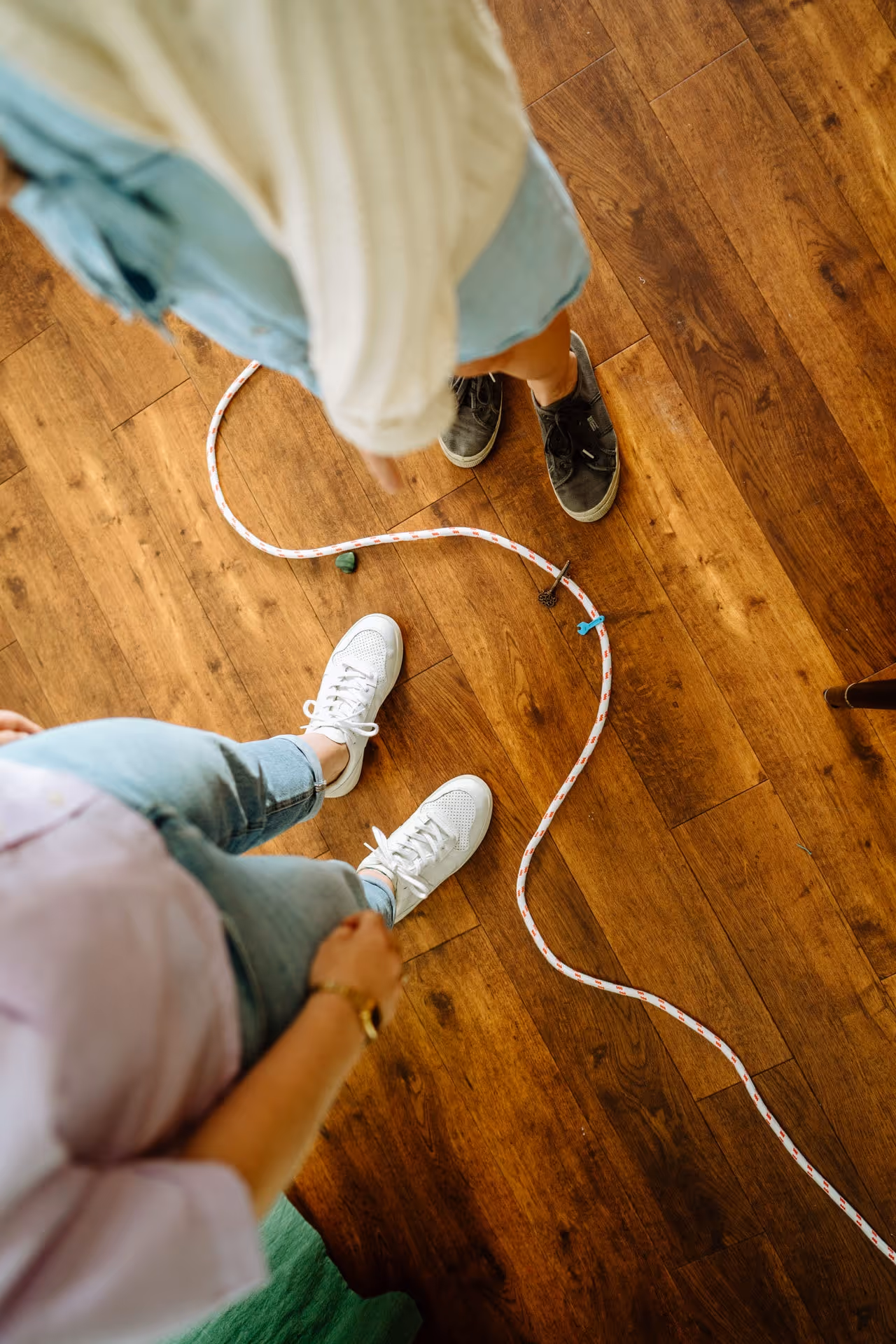 Seil liegt geschwungen auf Boden, Wera und Klientin stehen links und rechts davon.