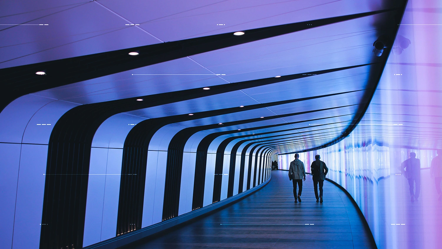 People walking down purple brightly lit hallway