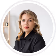 Portrait of a woman with blonde hair wearing a black shirt, looking at the camera against a light background.