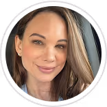 Portrait of a smiling woman with long light brown hair, wearing light makeup and small earrings.