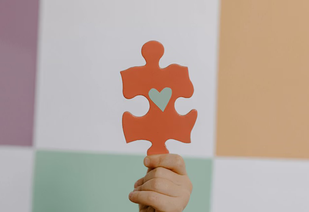 Person holds heart puzzle piece symbolizing autism evaluation, treatment, and collaborative care in San Jose, CA.