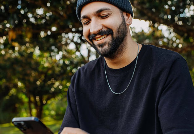 Man in San Jose discusses mood disorders treatment and comprehensive care in talk therapy session, holding a cell phone.