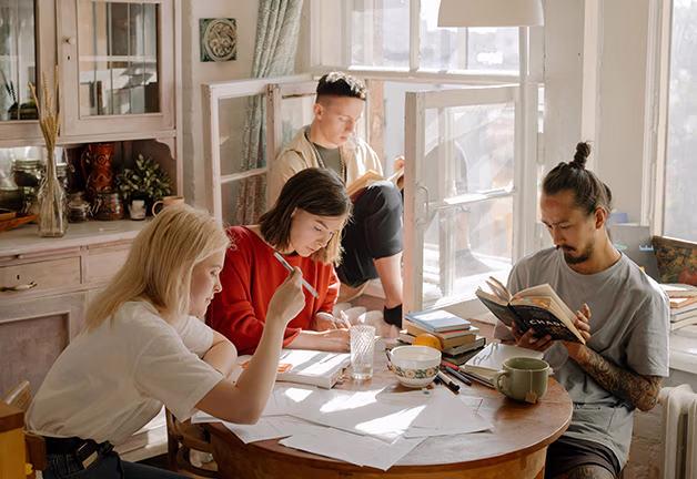 People in San Jose, CA, receive guidance and support at a table with books and papers, discussing test results.