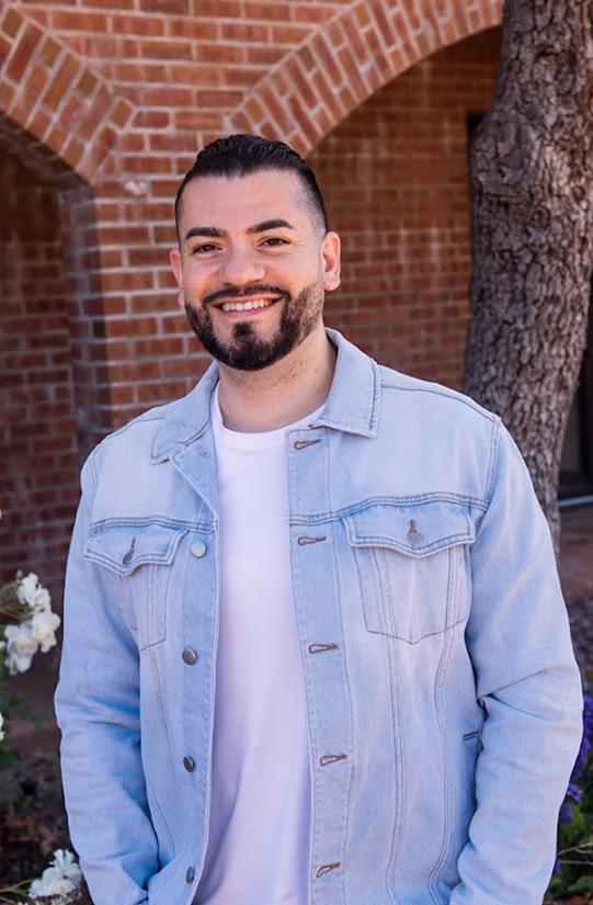 Dr. Trace Huang smiling at the camera while outdoors in casual clothes.