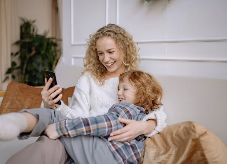 Woman in San Jose, CA on couch with child, using therapy to reduce conflict, improve communication, and support growth.